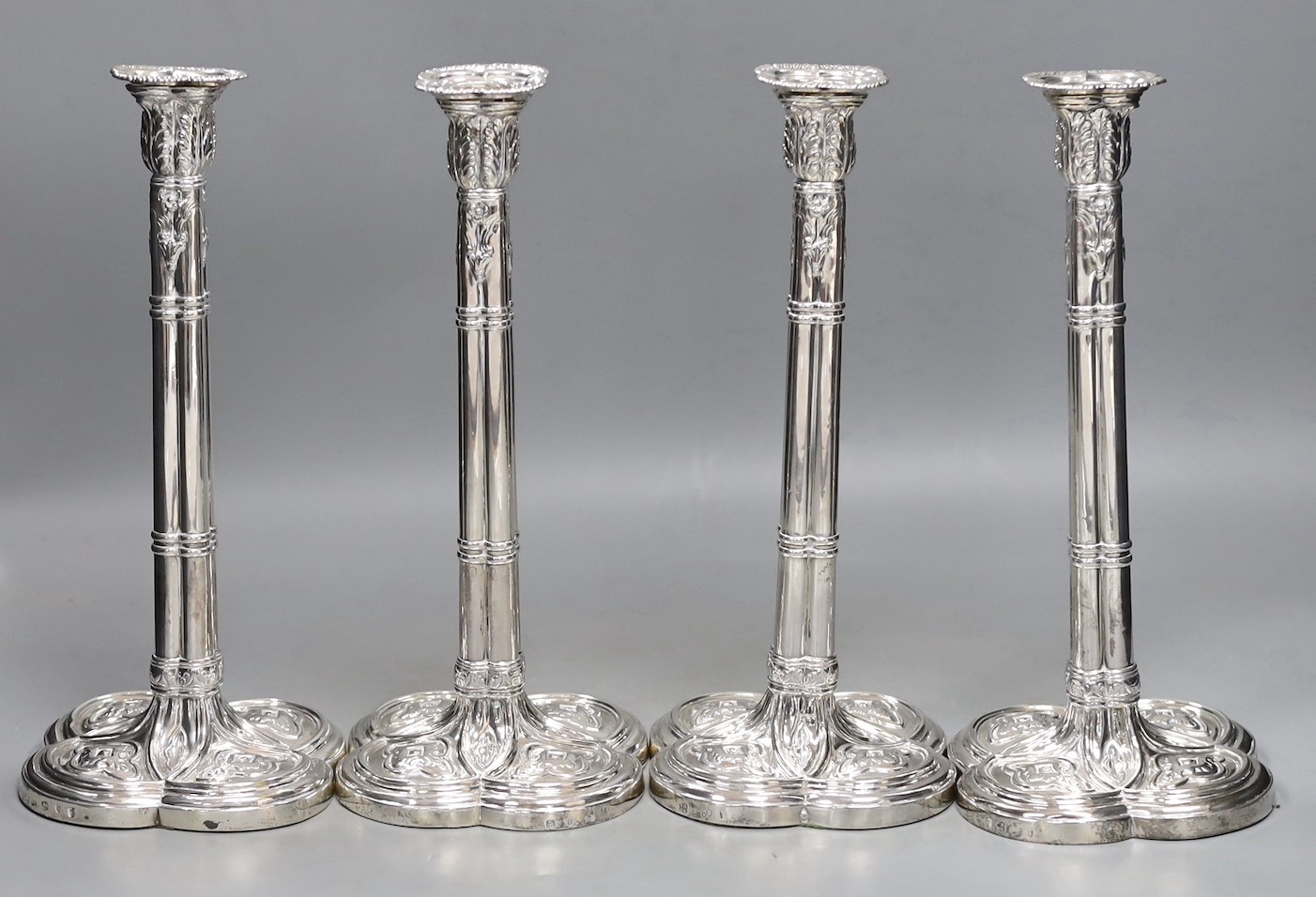 A set of four early George III silver gothic cluster column candlesticks, on cusped quatrefoil bases, by Hannam or Hammond & Carter, London, 1763, 28.8cm, weighted (holes).